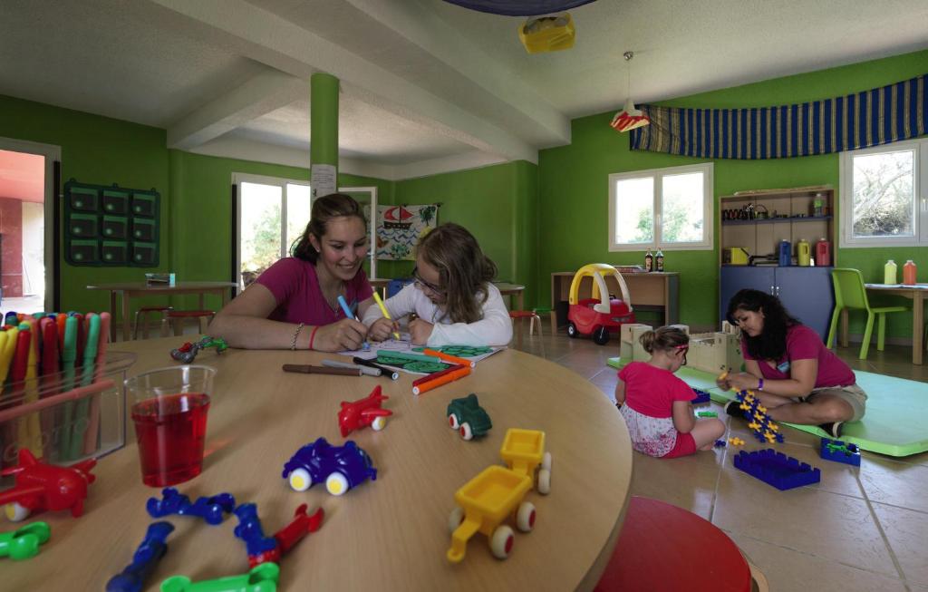 a woman and two girls playing with toys at a table at Belambra Clubs Presqu&#39;île De Giens - Riviera Beach Club in Hyères