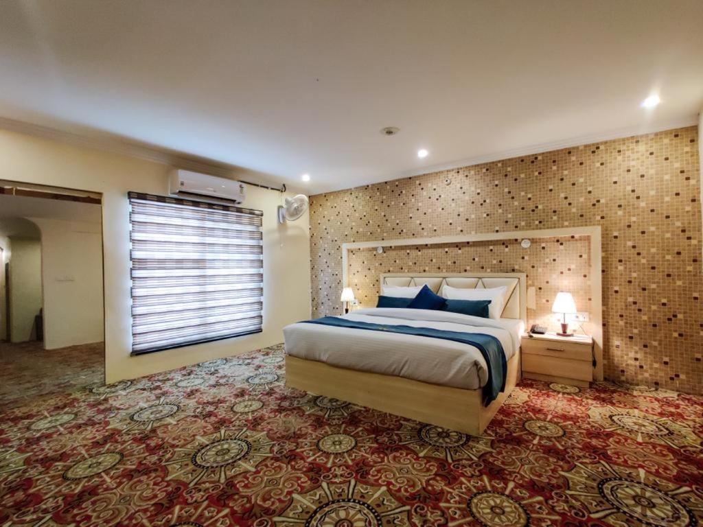 - une chambre avec un grand lit et une fenêtre dans l'établissement WEST COTTAS HOTEL -- Couples, Family, Corporate Favorite in Heart of Jalandhar, à Jalandhar