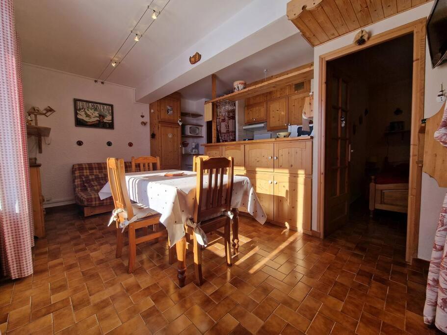 eine Küche mit einem Tisch und 2 Stühlen in einem Zimmer in der Unterkunft Appartement - Vue Mont-Blanc in Cordon