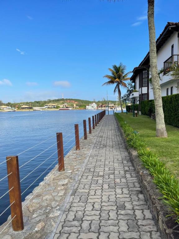 a cobblestone road next to a body of water at Le Corsaire in Búzios