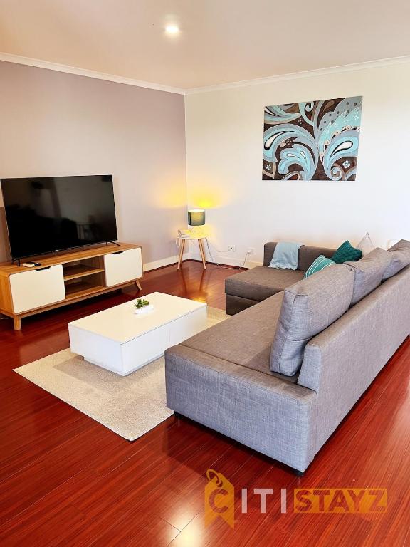 un soggiorno con divano e TV di Spacious 1bd Penthouse - Close to ANU a Canberra