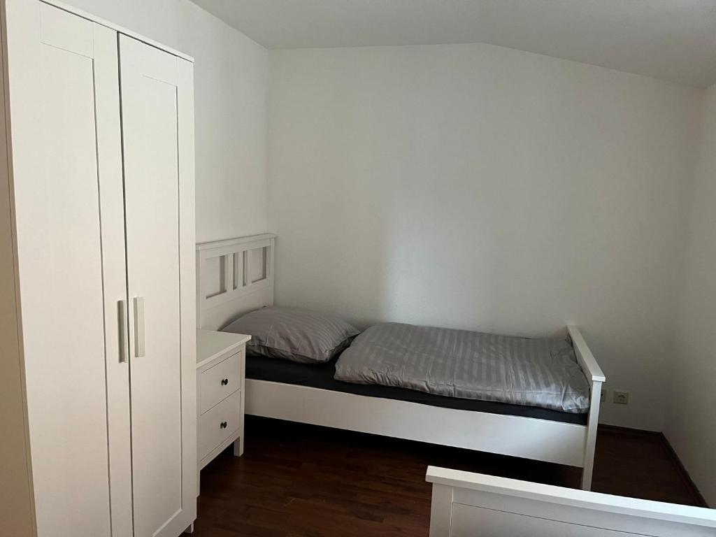 ein kleines Schlafzimmer mit einem Bett und einer Kommode in der Unterkunft FeWo Köthen 