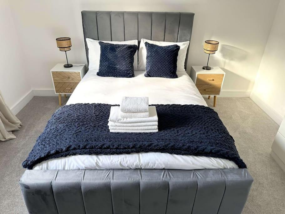 a bedroom with a large bed with a blue blanket at Thorpe House - Home Crowd Luxury Apartments in Doncaster