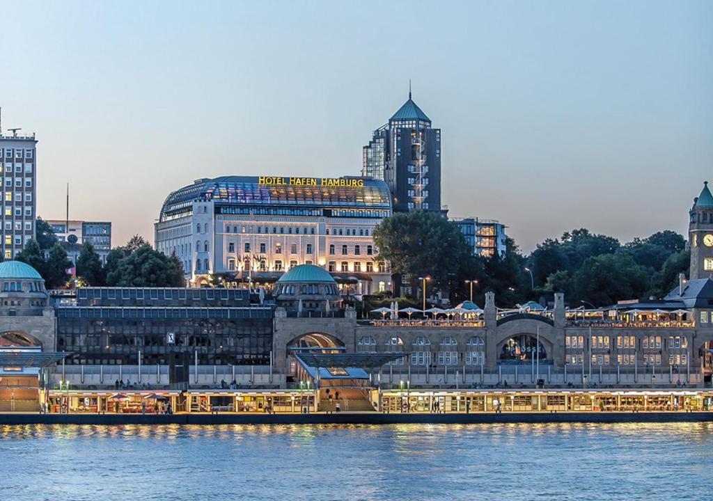 ein großes Gebäude neben einem Wasserkörper in der Unterkunft Hotel Hafen Hamburg in Hamburg