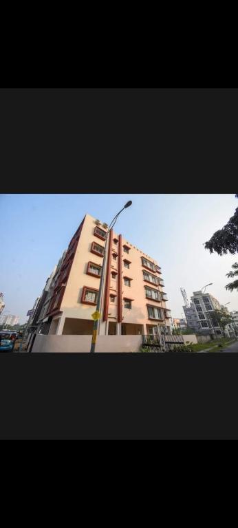 um edifício alto com uma luz de rua em frente em OYO Cv Guest House Near Rdb Cinemas em Calcutá