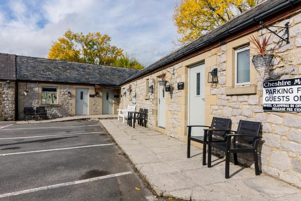 a building with tables and chairs in a parking lot at Cheshire Mews in Castleton