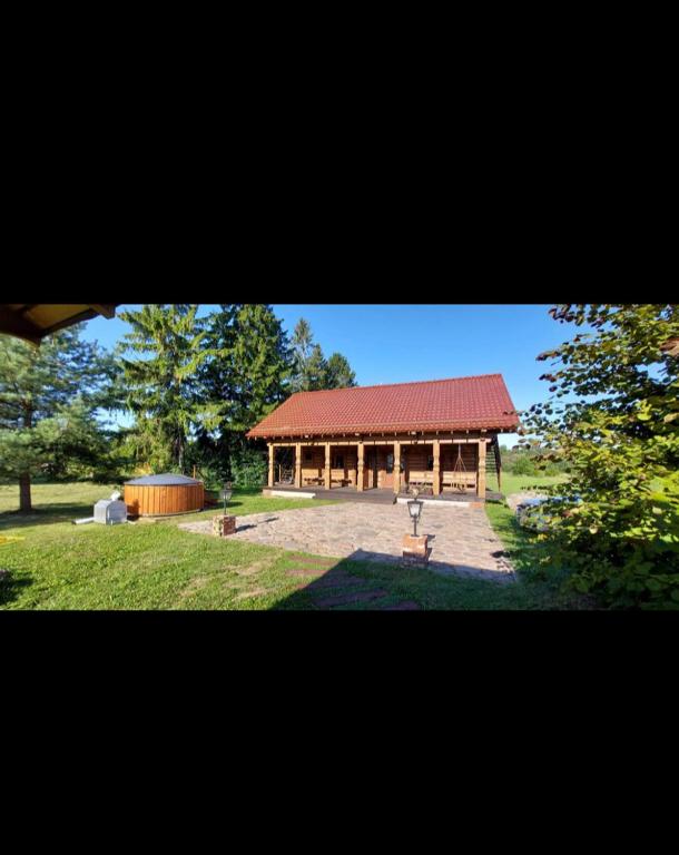 a large building with a red roof in a park at Drulenu sodyba in Drūlėnai