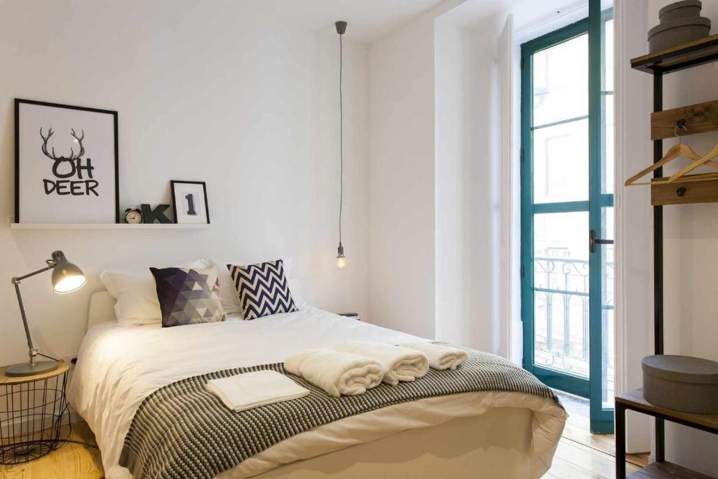 a bedroom with a bed with towels on it at Urban Design Estudio no Centro com Ar Condicionado in Lisbon