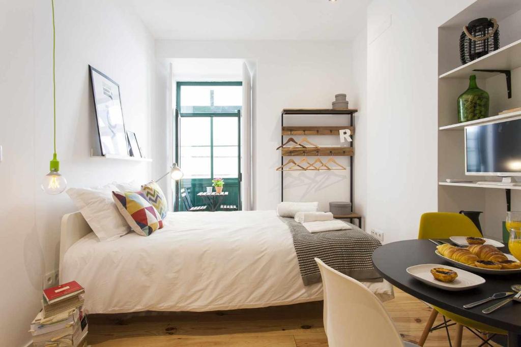 um quarto branco com uma cama e uma mesa em Green Centro da Cidade Ar Condicionado em Lisboa