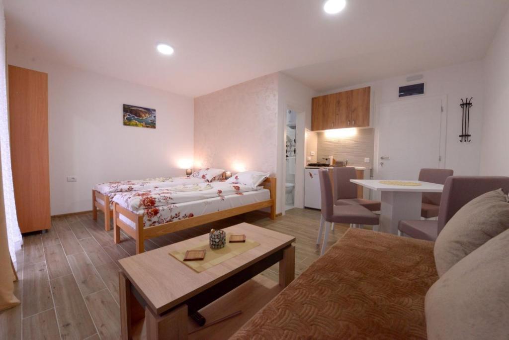 a hotel room with a bed and a living room at Apartmani Rvović in Nova Varoš