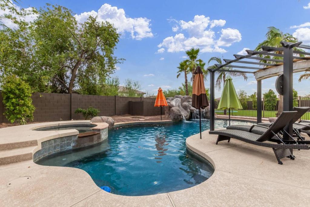 una piscina en un patio con sillas y sombrilla en Leland Luxury, en Mesa