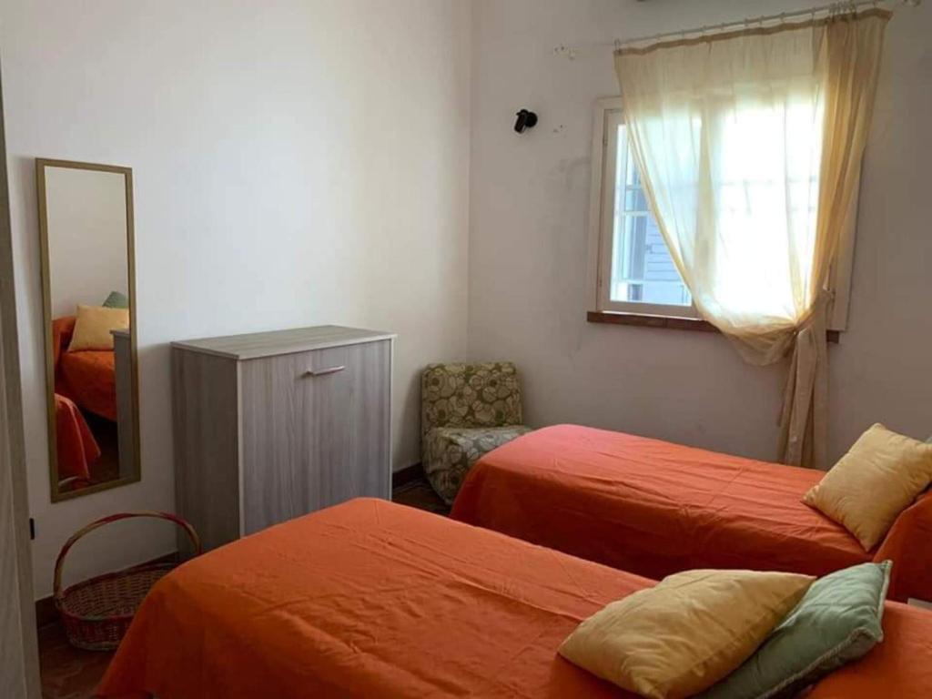 a bedroom with two beds and a mirror and a chair at Villa Dei Pini in San Pietro in Bevagna