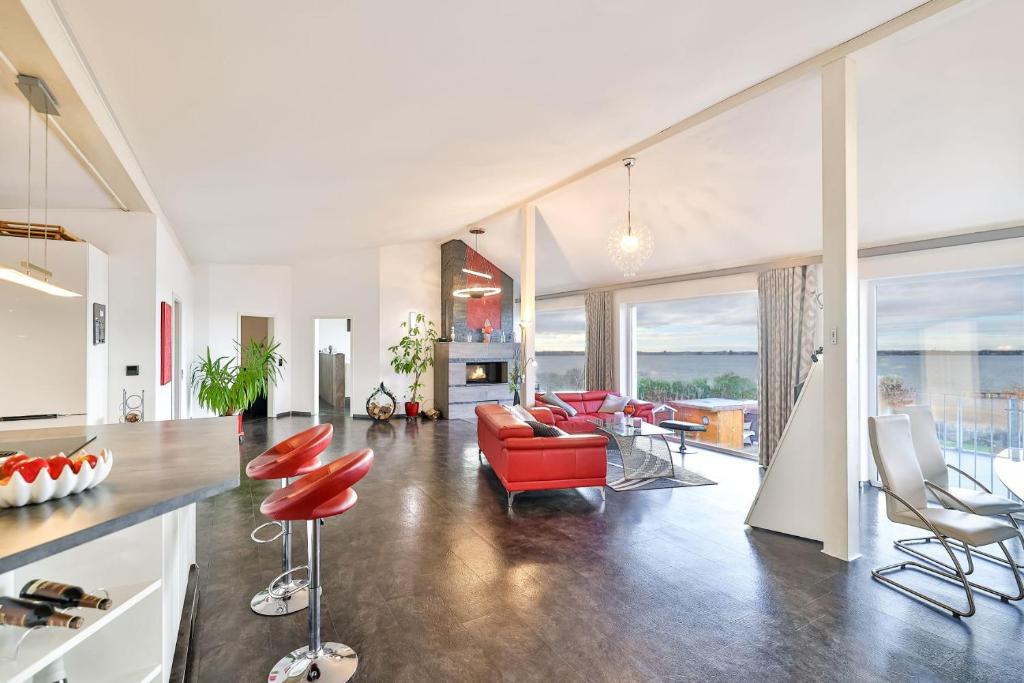 a living room with a red couch and chairs at Panoramalodge Rügen in Altefähr