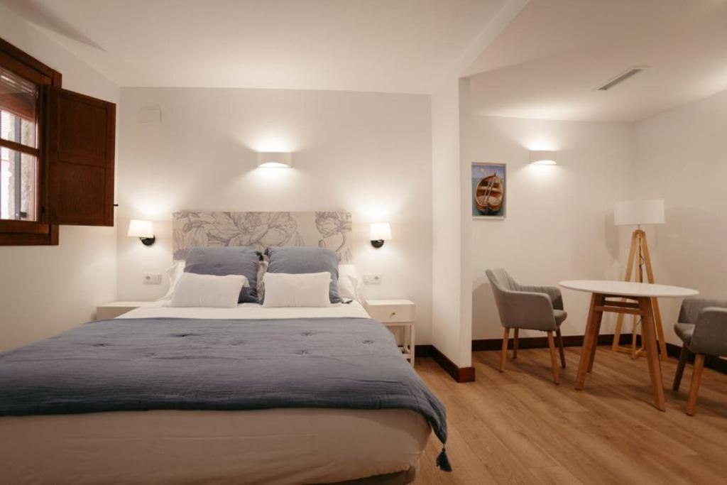 a bedroom with a large bed and a table at La Plaza Hostal in Peniscola