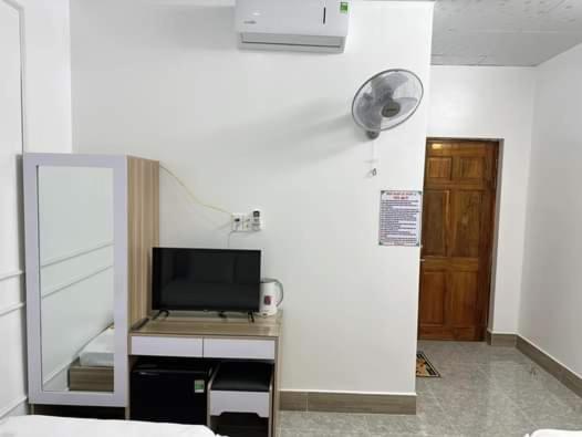 a room with a desk with a television and a door at NHÀ NGHỈ LÊ ĐƯỢC 2 in Ha Tien