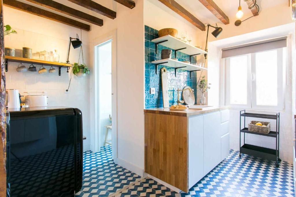 a kitchen with a counter and a tv in a room at Studio Blue LX- 1 de Maio in Lisbon