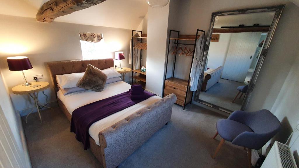 1 dormitorio con 1 cama grande y espejo en Holly Cottage, Hidden gem in the Yorkshire wolds en Welton