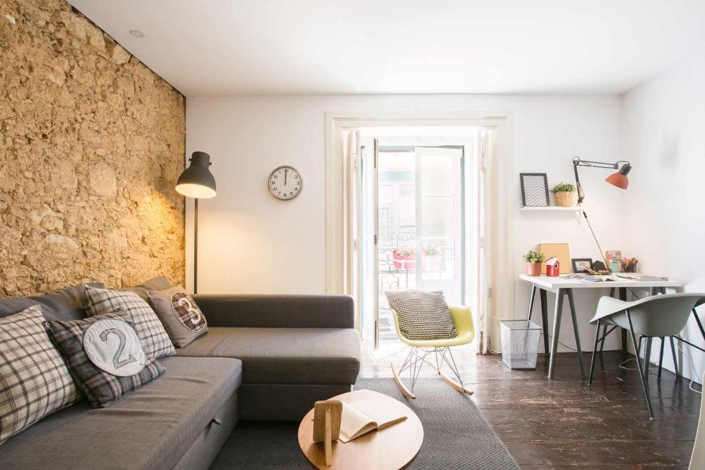 uma sala de estar com um sofá e uma mesa em Confortável Apartamento Centro da Cidade Univ em Lisboa