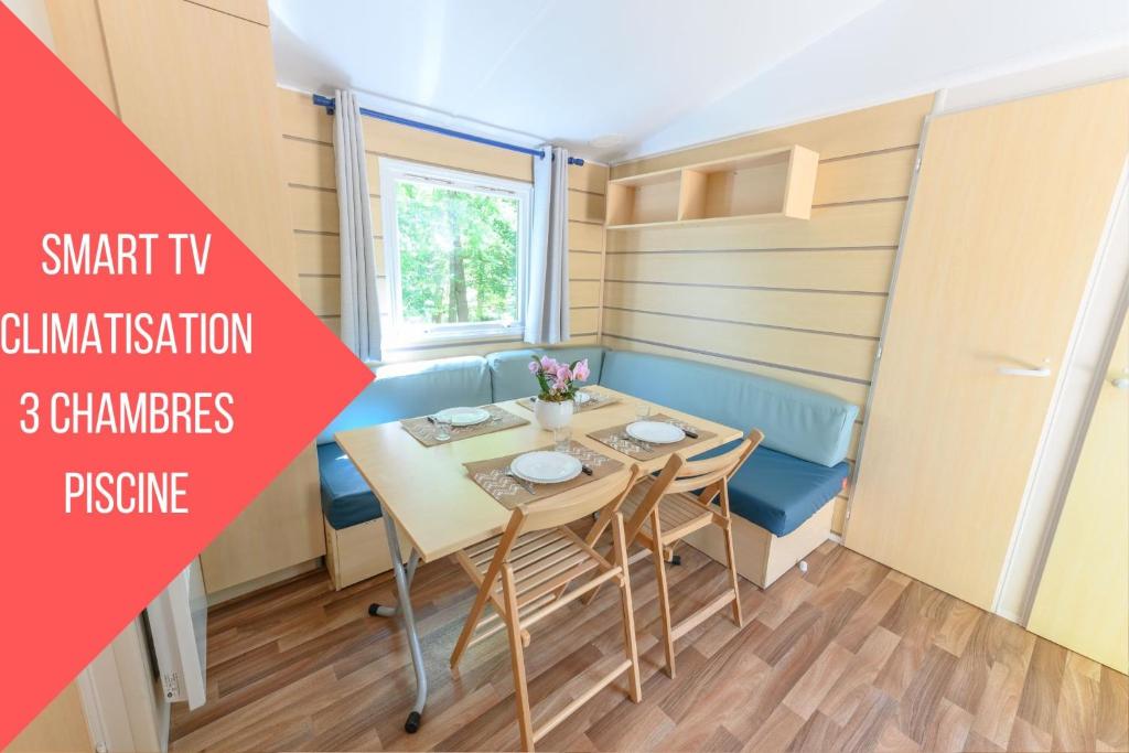 a tiny house dining room with a table and chairs at Mobil-home le ROBINSON in Mirgaudon