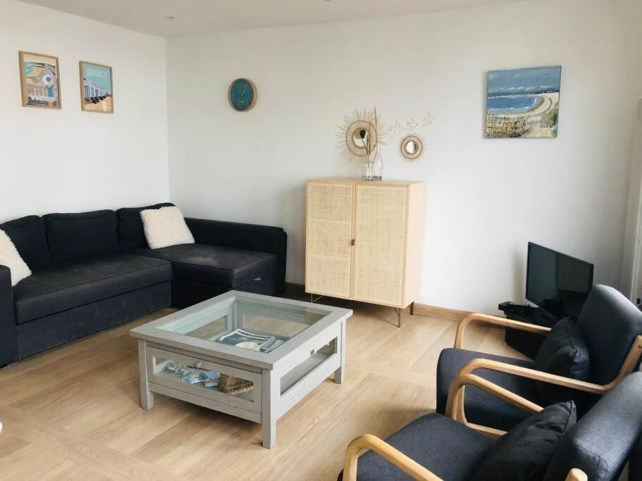 a living room with a couch and a coffee table at Appartement A confortable et lumineux in Neufchâtel-Hardelot