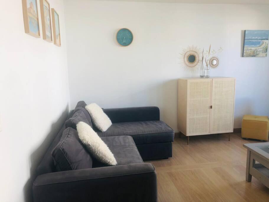 a living room with a couch and a table at Appartement A confortable et lumineux in Neufchâtel-Hardelot