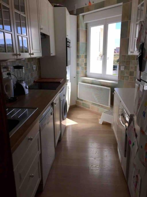 a kitchen with white cabinets and a window in it at Appartement A confortable et lumineux in Neufchâtel-Hardelot