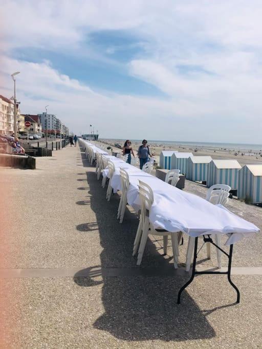 a row of white tables and chairs on the beach at Appartement A confortable et lumineux in Neufchâtel-Hardelot