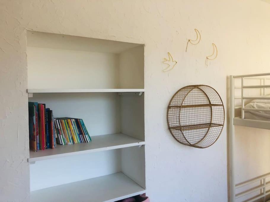 a room with white shelves with books at Appartement A confortable et lumineux in Neufchâtel-Hardelot