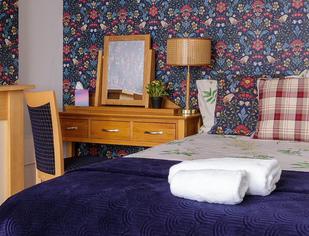 um quarto com uma cama com um espelho e uma cómoda em Blue Sparrow House - parking em Portsmouth