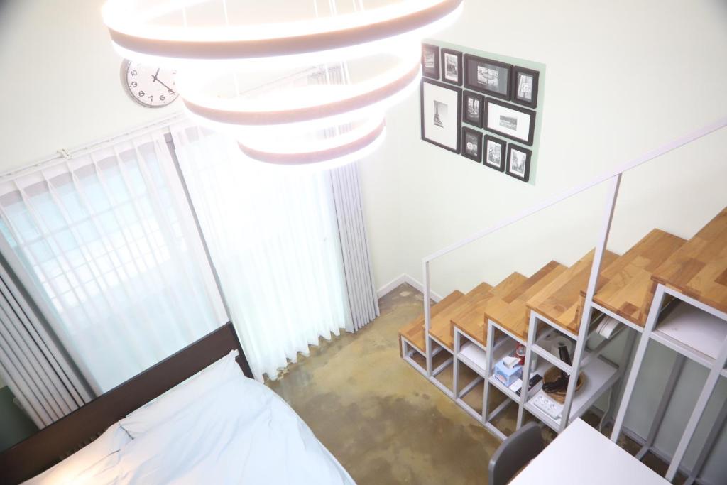 einen Blick über ein Zimmer mit einem Bett und einer Treppe in der Unterkunft LikeU Guest house in Seoul