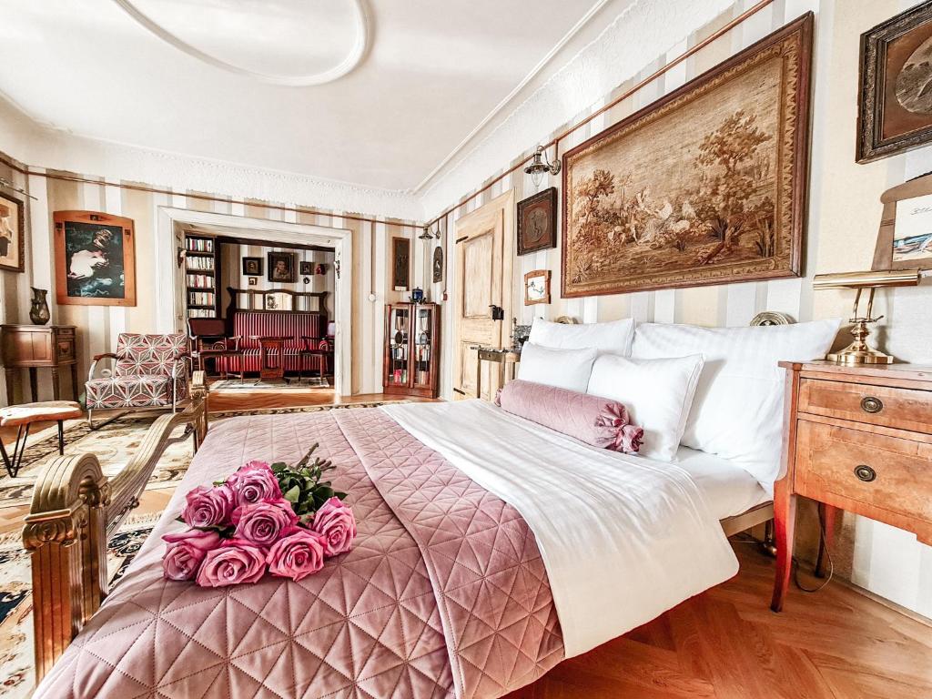 ein Schlafzimmer mit einem großen Bett mit Rosen darauf in der Unterkunft Divná pani Luxury Gallery Rooms in Banská Štiavnica