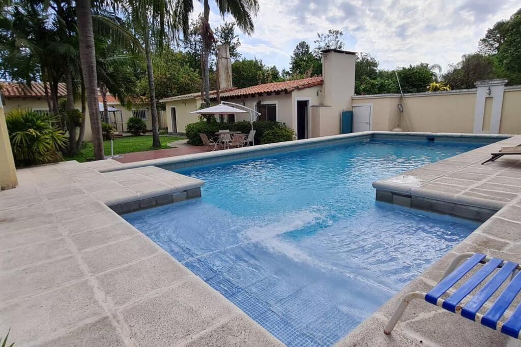 a swimming pool with a chair and a house at Casa quinta en la ruta 1 km 3.5 in Santa Fe