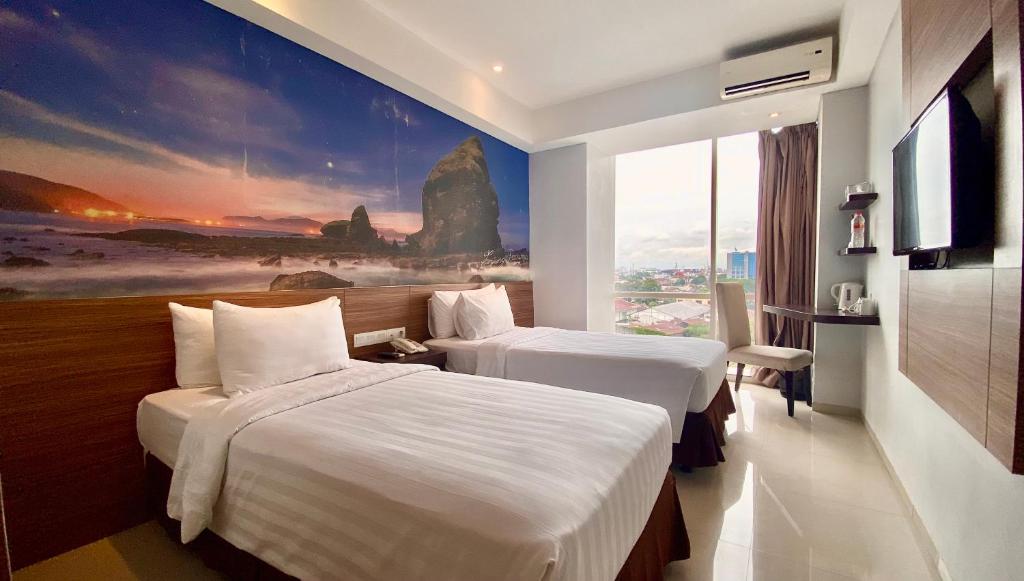 ein Hotelzimmer mit 2 Betten und einem Gemälde an der Wand in der Unterkunft Ascent Premiere Hotel and Convention in Malang