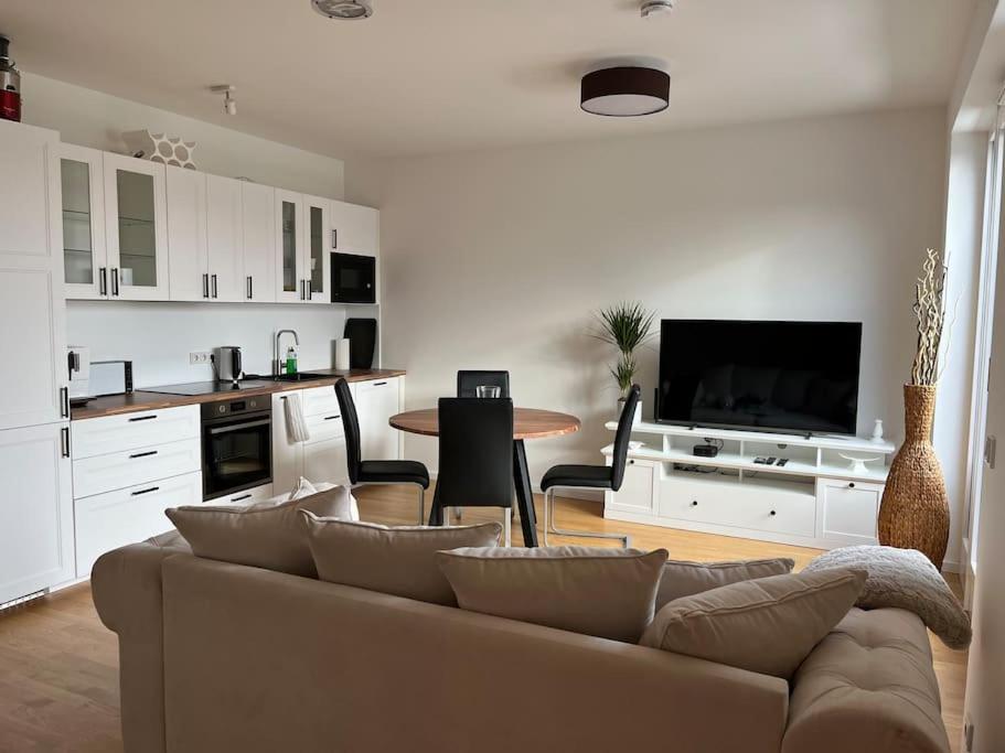 a living room with a couch and a kitchen at Gemütliches Appartement am Völkerschlachtdenkmal in Leipzig