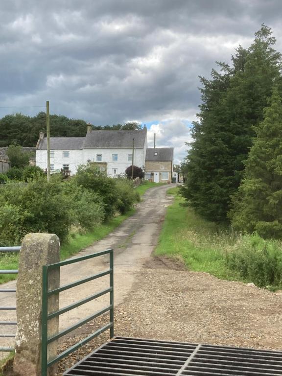 een onverharde weg met een poort in een dorp bij Whiteside Granary in Haltwhistle