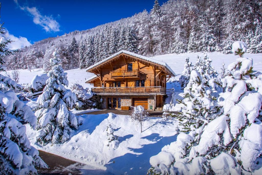 a log cabin in the snow with snow covered trees at Chalet Alex - OVO Network in Saint-Jean-de-Sixt