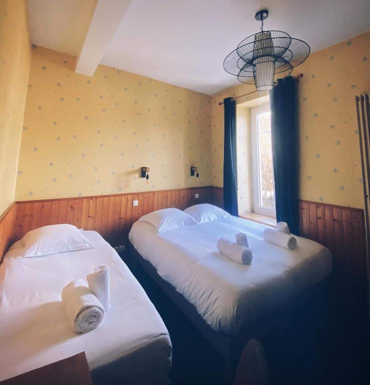 two beds in a room with towels on them at Hôtel Restaurant "La Petite Auberge" in Bourg-Saint-Maurice