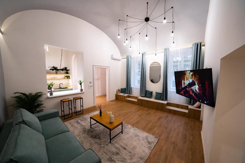 sala de estar con sofá verde y TV en Coente Apartments Király 28 en Budapest