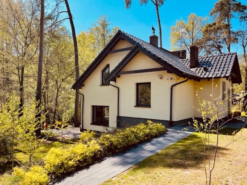 una pequeña casa blanca con un camino en Dom Blisko Natury Boszkowo Letnisko Dom A en Boszkowo-Letnisko