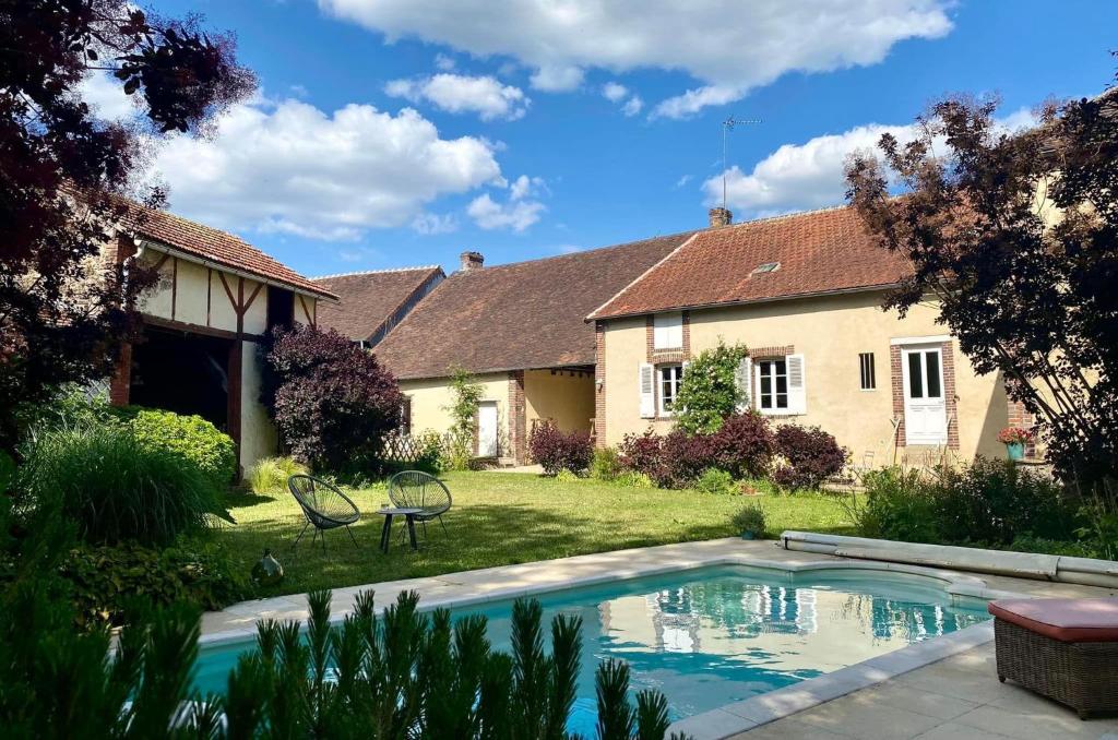 a house with a swimming pool in the yard at Au fil de L'Ouanne 