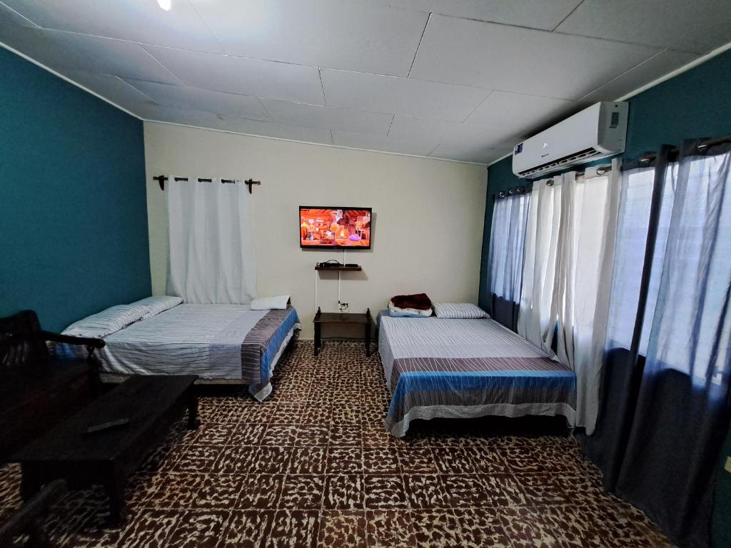 Habitación con 2 camas y piano en Hostal Lima Verde, en La Lima