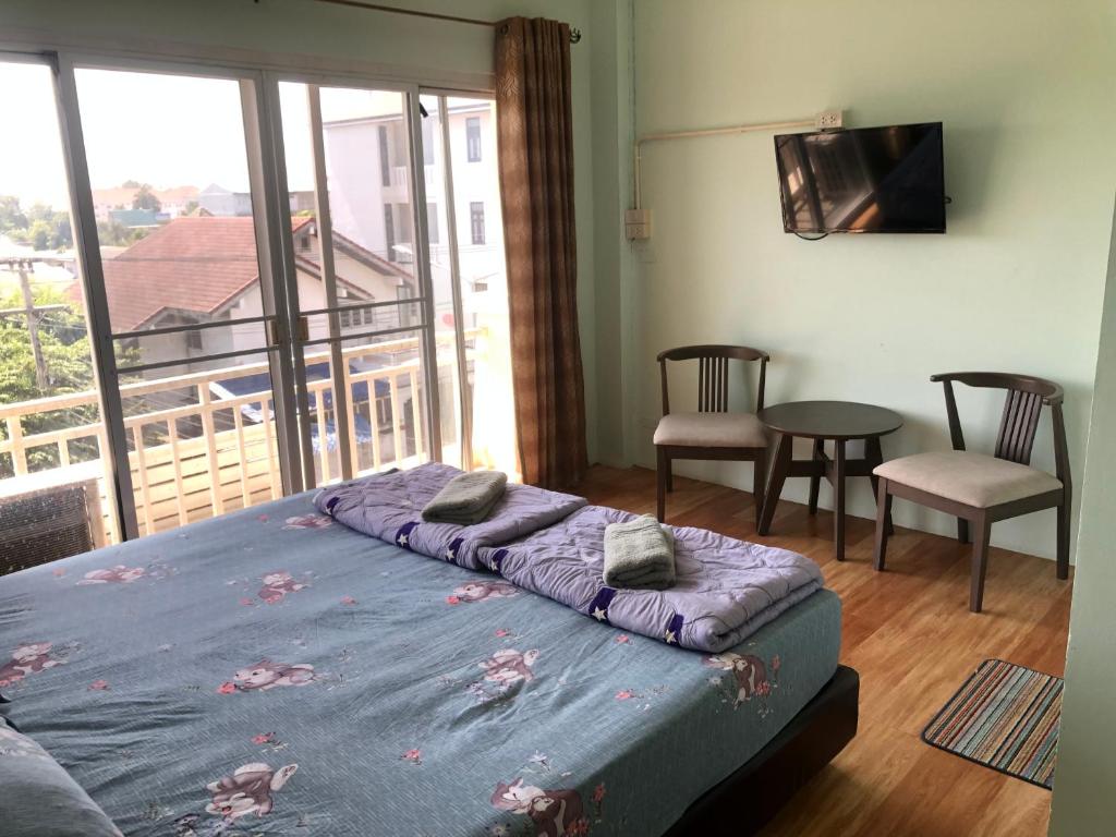 a bedroom with a bed and a balcony at บ้านยายกิ้ว in Phra Nakhon Si Ayutthaya