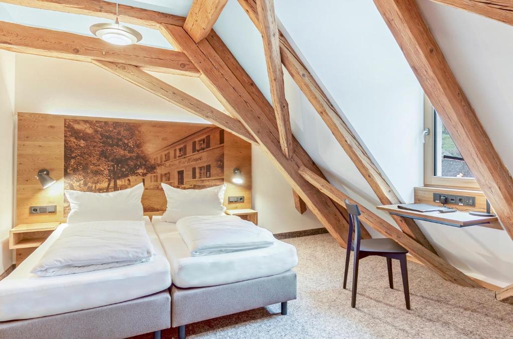 Duas camas num quarto no sótão com uma secretária. em Zum Alten Fritz em Weigendorf