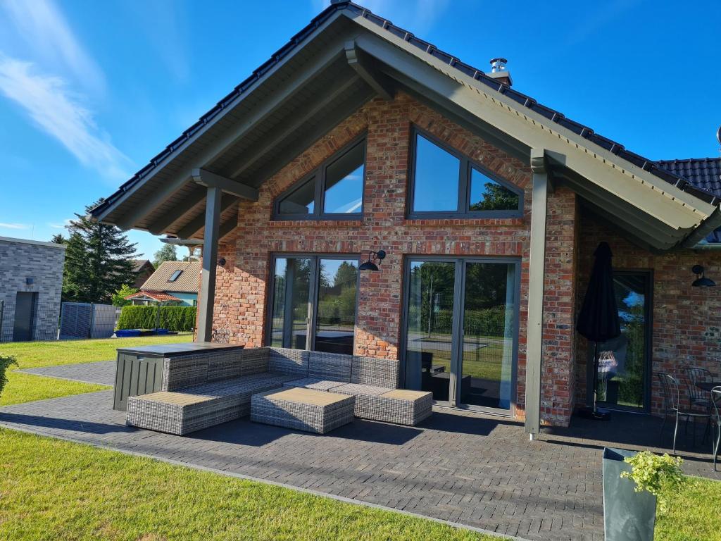 a brick house with large glass doors and benches at Ruegen Ferienhaus 300 in Sehlen