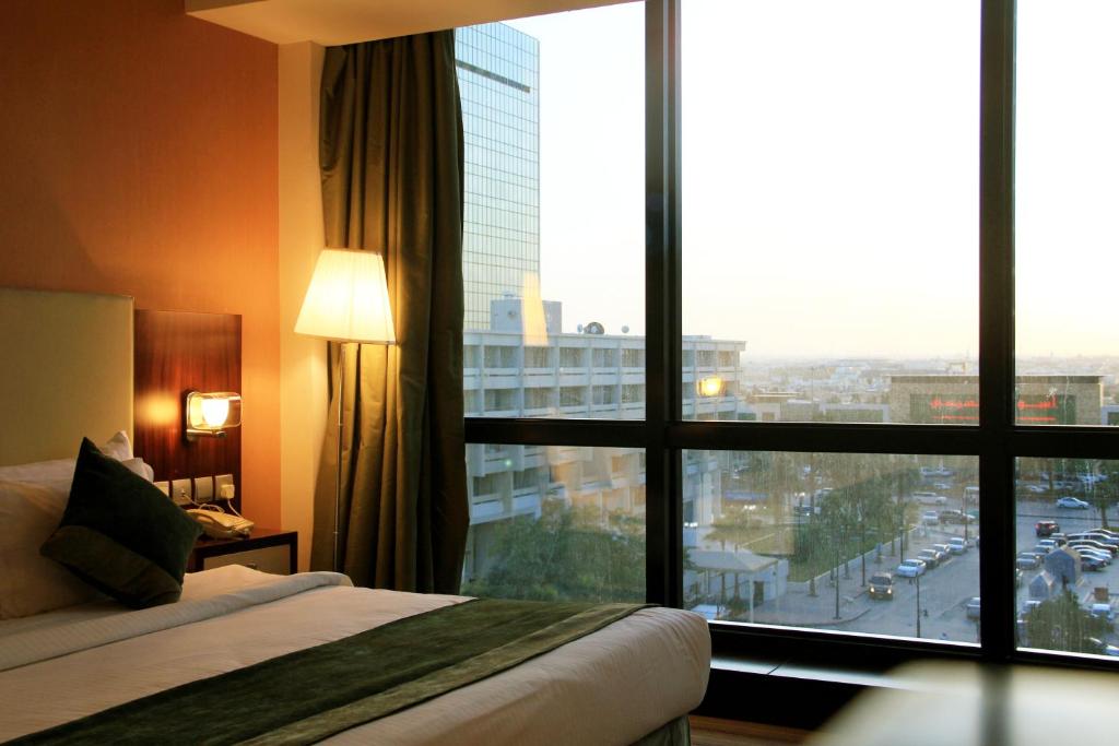Business Inn Olaya في الرياض: غرفة فندقية بسرير ونافذة كبيرة
