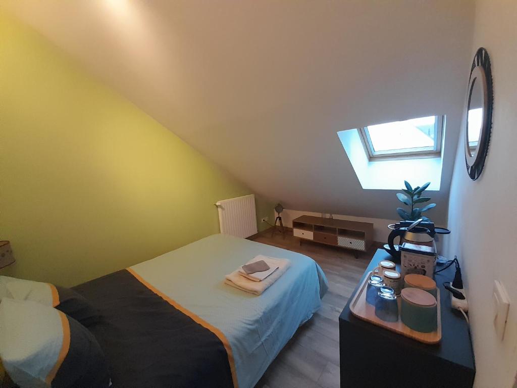 een kleine slaapkamer met een bed en een raam bij Chez Marie et Hugo in Crépy-en-Valois