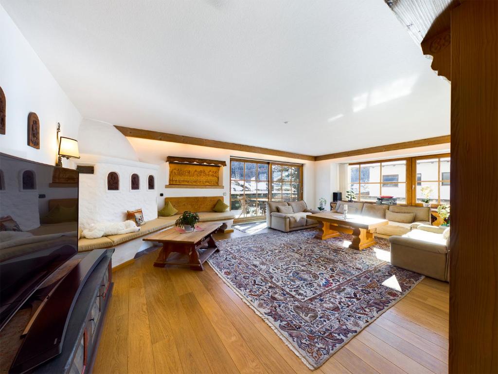 een woonkamer met een bank en een tv bij Schnitzerstube in Mittenwald