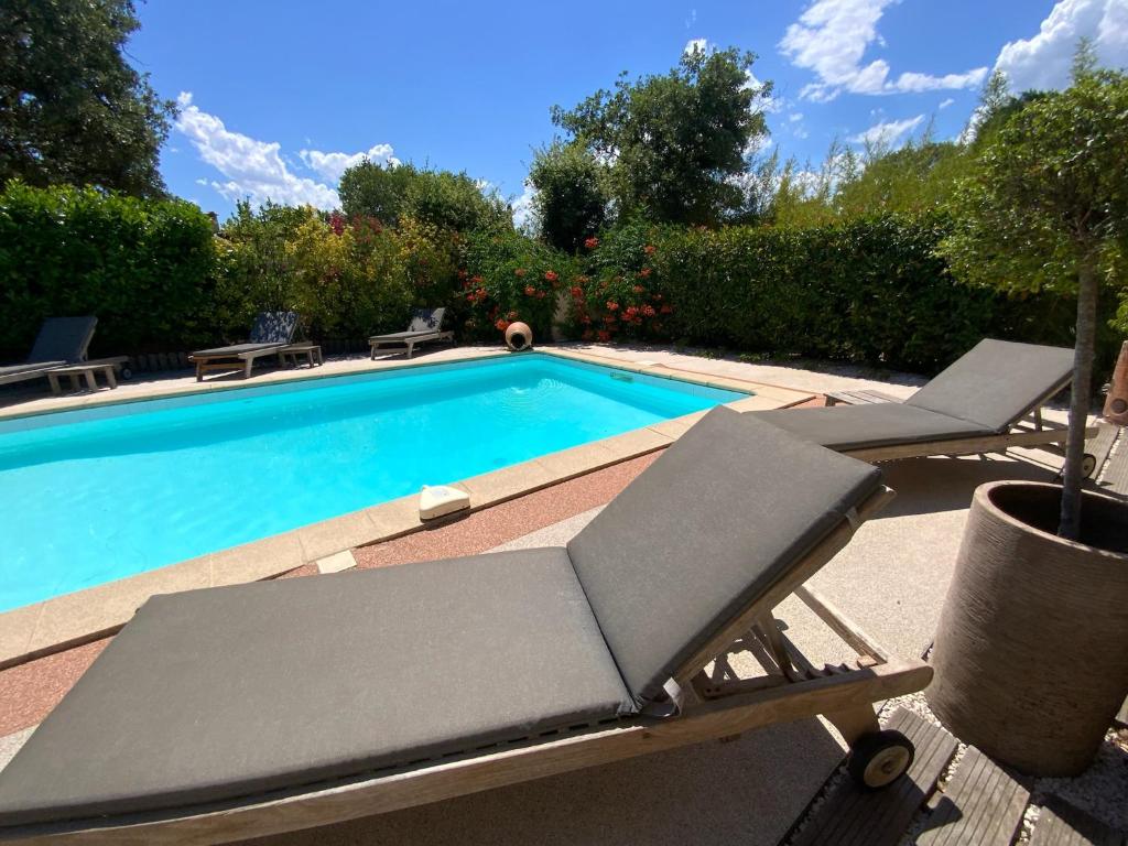 - une piscine avec une chaise longue à côté dans l'établissement Villa climatisée, piscine privée chauffée, Fitness proche Cannes, Fréjus, St Raphael, Grasse, à Montauroux