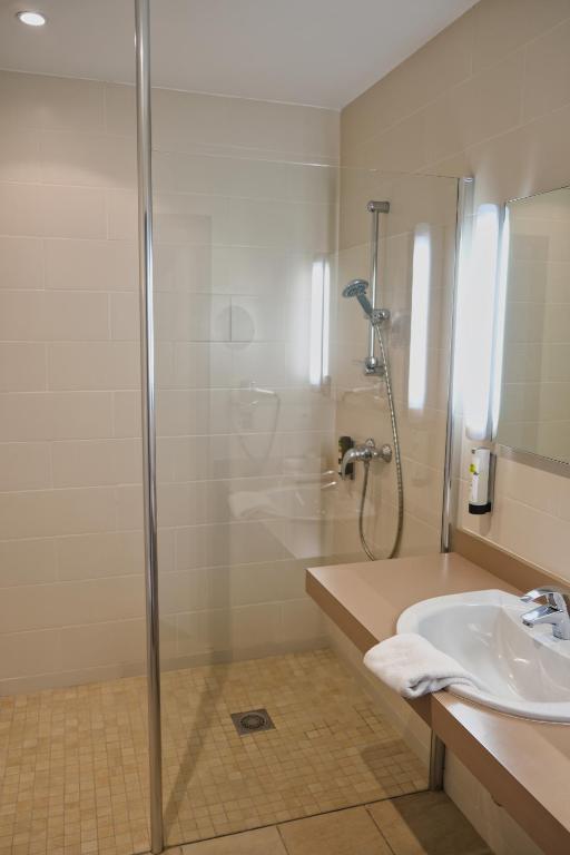 a bathroom with a shower and a sink at Hôtel Arcadia in Lannion