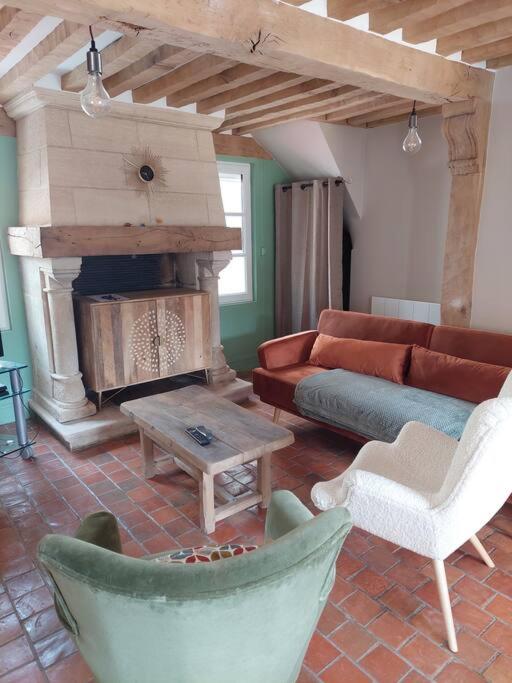 a living room with a couch and a fireplace at Un Brin de folie dans le centre de Honfleur in Honfleur